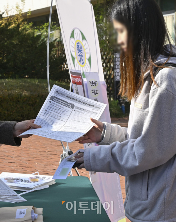 ▲2026학년도 대학수학능력시험을 하루 앞둔 12일 서울 중구 이화여고에서 한 수험생이 수험표와 수험생 유의사항 안내문을 받고 있다. 조현호 기자 hyunho@