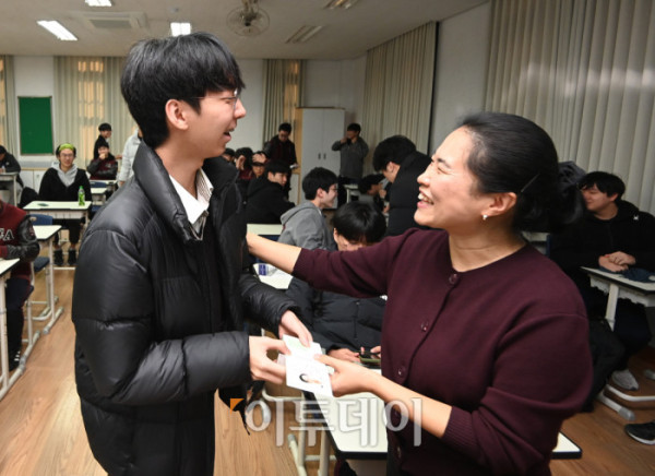 ▲2026학년도 대학수학능력시험을 하루 앞둔 12일 서울 종로구 중앙고등학교에서 담임 선생님이 고3 수험생들에게 수험표를 배부하며 격려하고 있다. 조현호 기자 hyunho@