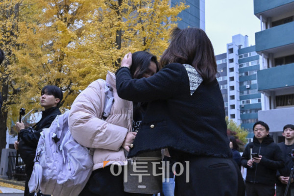 ▲2026학년도 대학수학능력시험일인 13일 서울 영등포구 여의도여자고등학교에 마련된 시험장 앞에서 수험생 가족이 수험생을 응원하고 있다. 조현호 기자 hyunho@