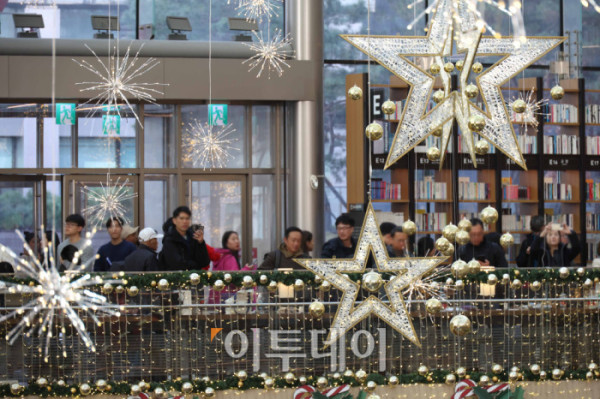 ▲20일 서울 삼성동 스타필드 코엑스몰 별마당 도서관에서 방문객들이 연말 분위기를 즐기고 있다. '책 속에서 펼쳐지는 크리스마스 축제' 를 주제로 마련된 이번 캠페인은 종이로 구현된 세 개의 챕터를 따라 도서관 전체가 한 권의 팝업북처럼 펼쳐진다. 방문객들은 페이지를 넘기듯 크리스마스 동화 속 세계를 체험할 수 있다. 고이란 기자 photoeran@ (이투데이DB)