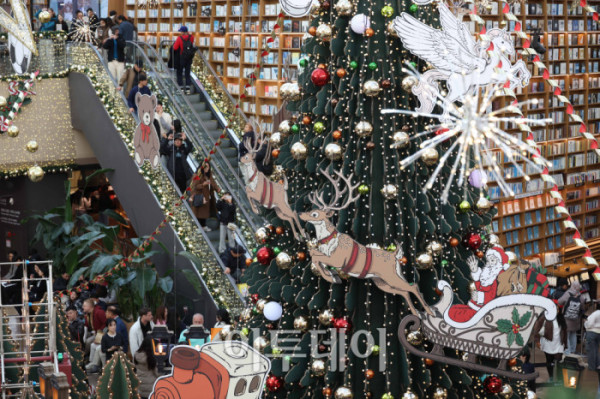 ▲20일 서울 삼성동 스타필드 코엑스몰 별마당 도서관에서 방문객들이 연말 분위기를 즐기고 있다. '책 속에서 펼쳐지는 크리스마스 축제' 를 주제로 마련된 이번 캠페인은 종이로 구현된 세 개의 챕터를 따라 도서관 전체가 한 권의 팝업북처럼 펼쳐진다. 방문객들은 페이지를 넘기듯 크리스마스 동화 속 세계를 체험할 수 있다. 고이란 기자 photoeran@ (이투데이DB)