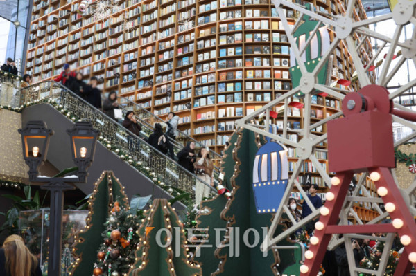▲20일 서울 삼성동 스타필드 코엑스몰 별마당 도서관에서 방문객들이 연말 분위기를 즐기고 있다. '책 속에서 펼쳐지는 크리스마스 축제' 를 주제로 마련된 이번 캠페인은 종이로 구현된 세 개의 챕터를 따라 도서관 전체가 한 권의 팝업북처럼 펼쳐진다. 방문객들은 페이지를 넘기듯 크리스마스 동화 속 세계를 체험할 수 있다. 고이란 기자 photoeran@ (이투데이DB)
