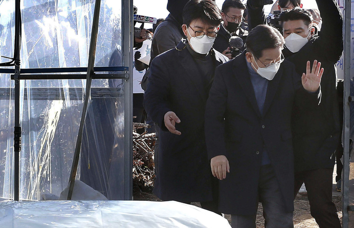 ▲이재명 더불어민주당 대선 후보가 13일 경북 성주군의 한 농원에서 참외 모종 심기 체험을 하기 위해 입장하다 한 남성이 사드배치를 비판하며 달걀을 투척해 출입문에 터졌다. 경호원이 이 후보를 보호하자 괜찮다며 손짓하고 있다. 2021.12.13.  (뉴시스)