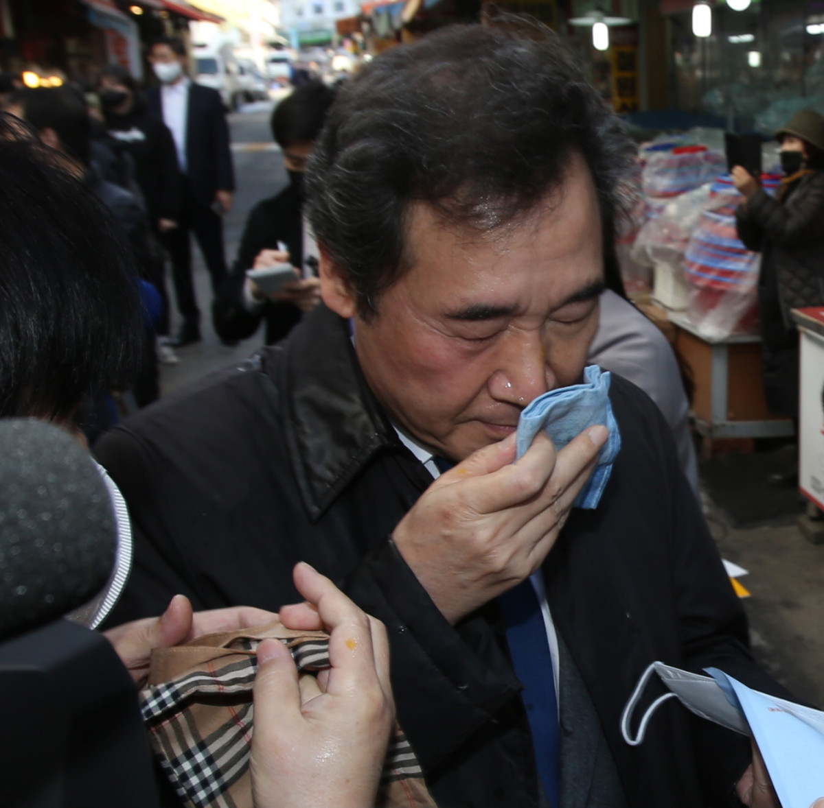 ▲이낙연 더불어민주당 대표가 5일 오후 민생탐방지로 찾은 강원도 춘천 중앙시장에서 중도유적지킴이본부 회원이 던진 계란을 맞고 손수건으로 닦고 있다. 2021.03.05.   (뉴시스)