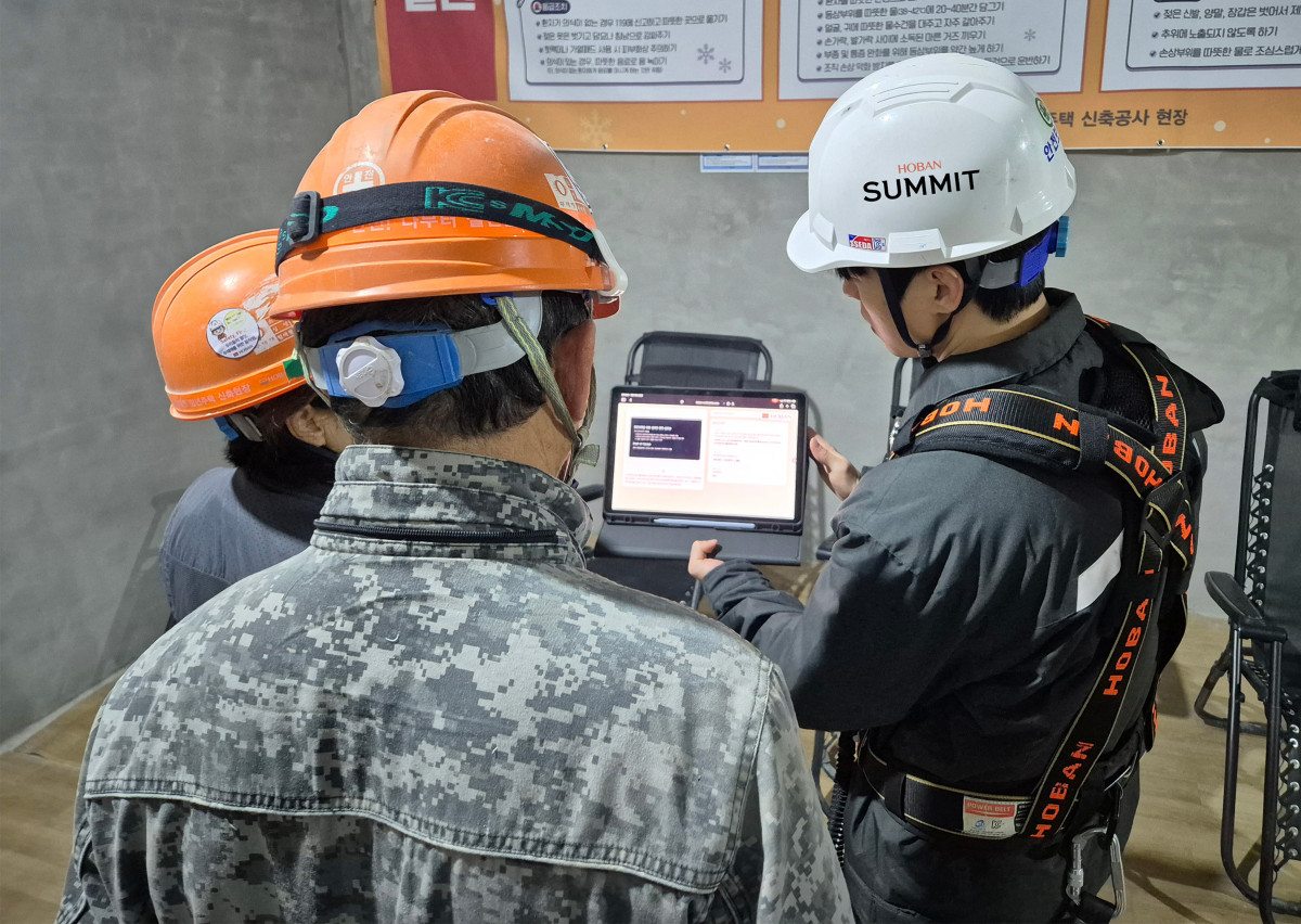 ▲호반건설 직원이 건설 현장에서 AI 동시번역 플랫폼 ‘호반커넥트’를 활용해 근로자들과 대화하고 있다. (호반건설)