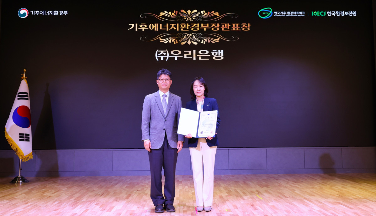 ▲(왼쪽부터)이현주 우리은행 ESG상생금융부장과 오일영 기후에너지환경부 기후에너지정책실장이 2일 서울 동작구 '서울여성플라자'에서 열린 '탄소중립 생활 실천 국민대회'에서 수상식을 마친 후 기념촬영을 하고 있다. (사진제공=우리은행)