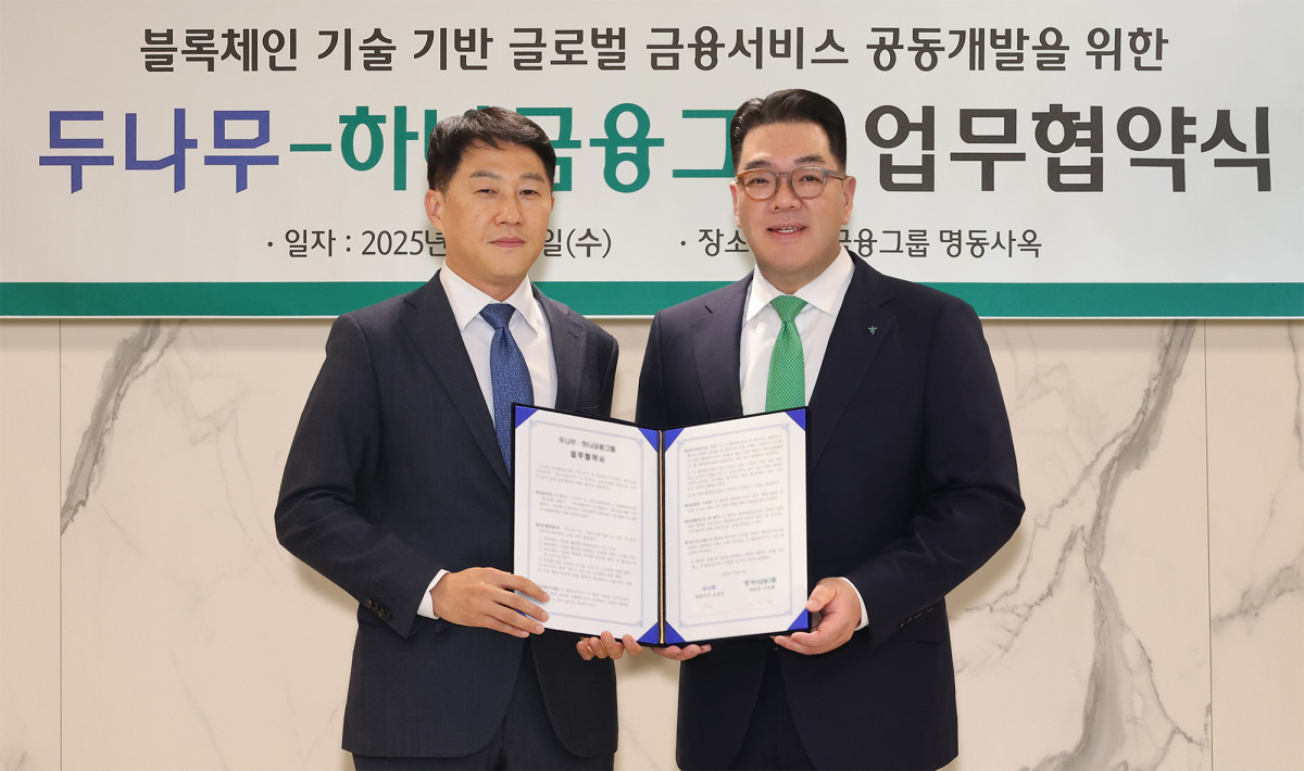 ▲이은형(사진 오른쪽) 하나금융그룹 부회장이 오경석 두나무 대표이사와 함께 협약서를 들고 기념촬영을 하고 있다. (사진제공=하나금융)