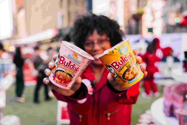 ▲외국인이 불닭볶음면 제품을 들고 있다. (사진제공=삼양식품)
