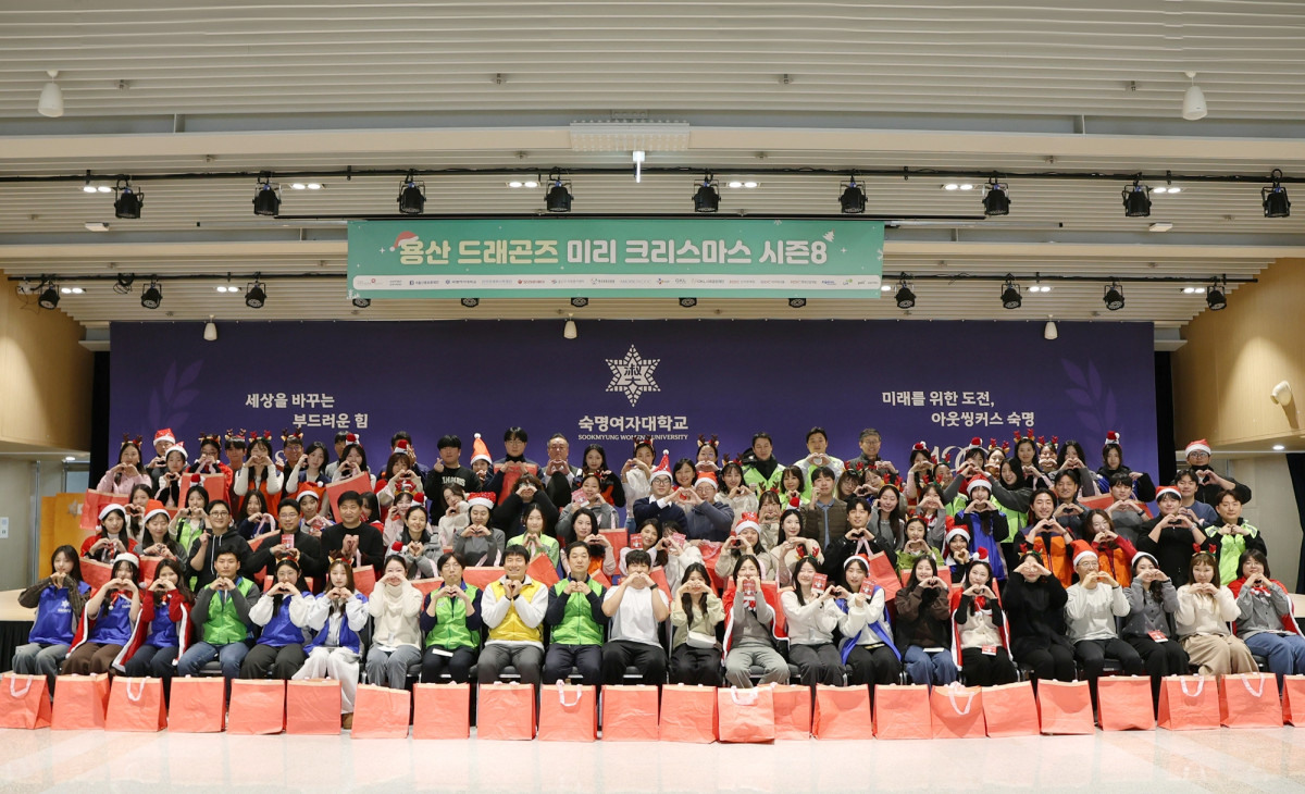 ▲민관학 연합봉사체 ‘용산 드래곤즈'가 서울 용산구 내 아동복지시설 어린이들에게 크리스마스 선물을 전달하고 기념사진을 찍고 있다. (사진제공=아모레퍼시픽)