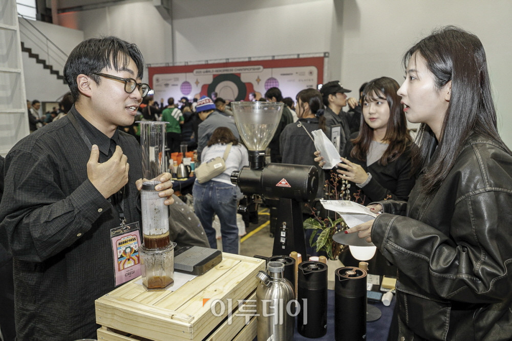 ▲6일 서울 성수동 레이어스튜디오 41에서 열린 ‘2025 월드 에어로프레스 챔피언십’ 현장에서 참가 부스 관계자가 에어로프레스를 활용한 추출 과정을 관람객에게 설명하고 있다. 사진제공=WAC