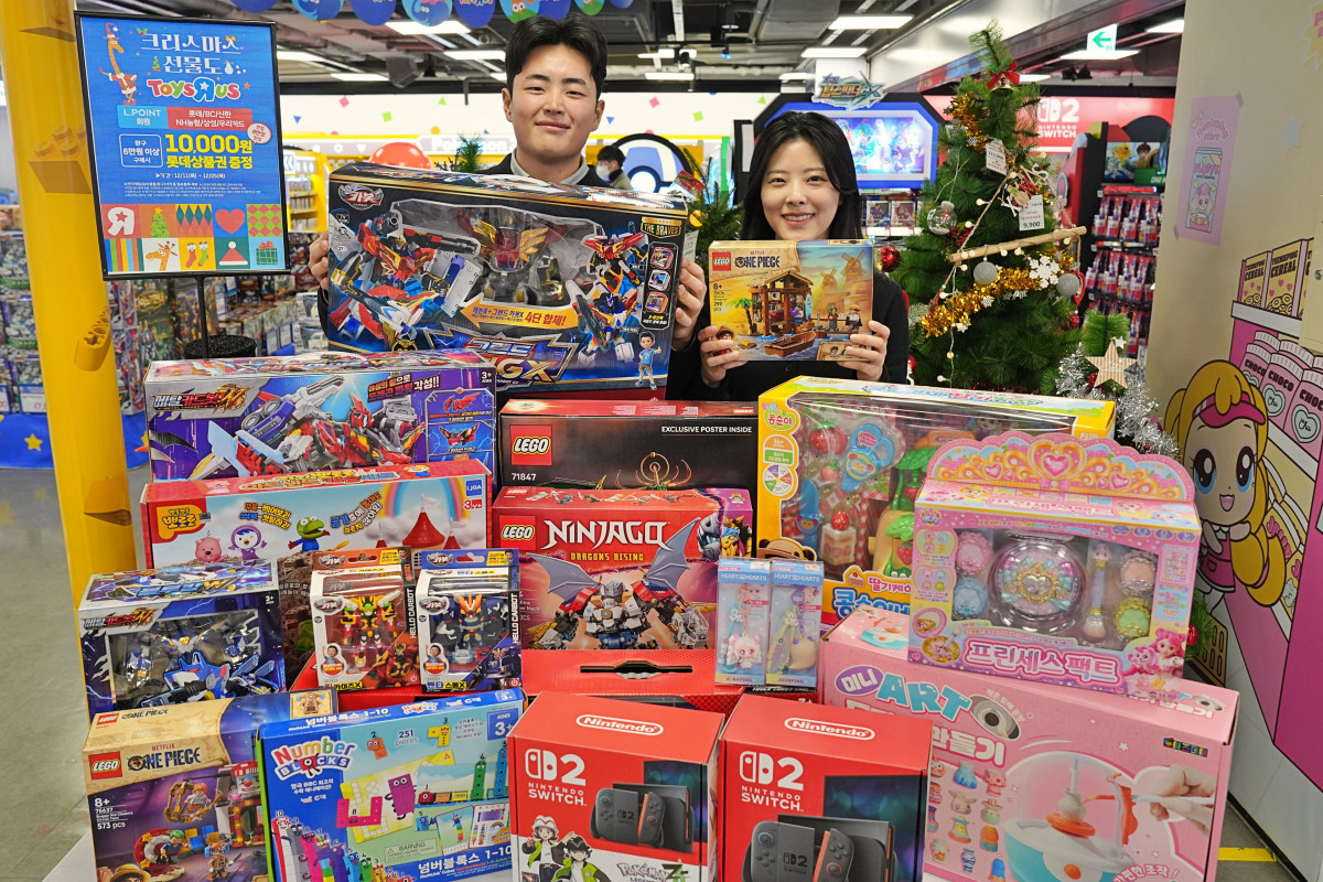 ▲롯데마트 토이저러스 직원들이 인기 완구를 들고 사진을 찍는 모습이다. (롯데마트)