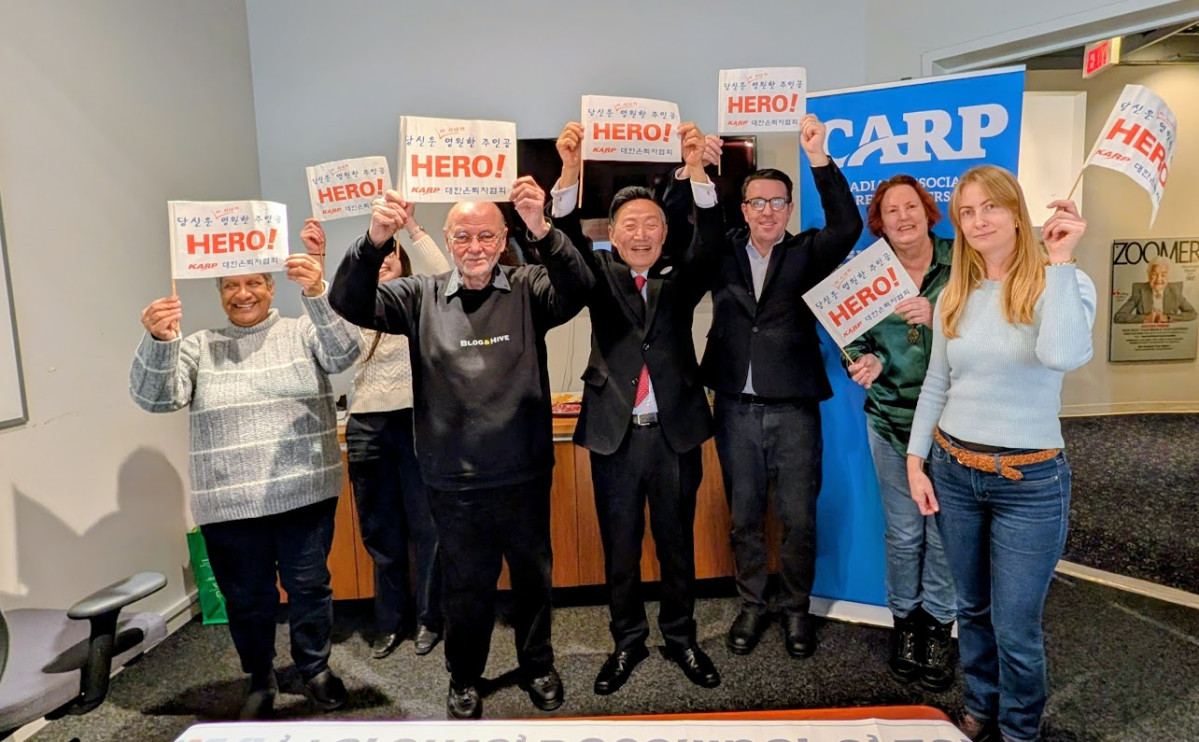 ▲대한은퇴자협회(KARP)와 캐나다은퇴자협회(CARP) 관계자들이 캐나다 토론토 본부에서 ‘당신은 이 시대의 영원한 주인공 HERO!’라는 문구가 적힌 깃발을 함께 펼쳐 보이며 양국 시니어의 권익 증진을 다짐하고 있다.(대한은퇴자협회 제공)