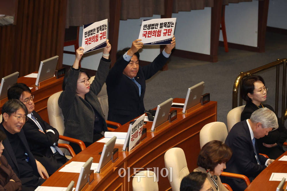 ▲윤종오 진보당 원내대표와 용혜인 기본소득당 대표가 11일 서울 여의도 국회에서 열린 본회의에서 국민의힘 규탄 피켓을 들고 있다. 고이란 기자 photoeran@