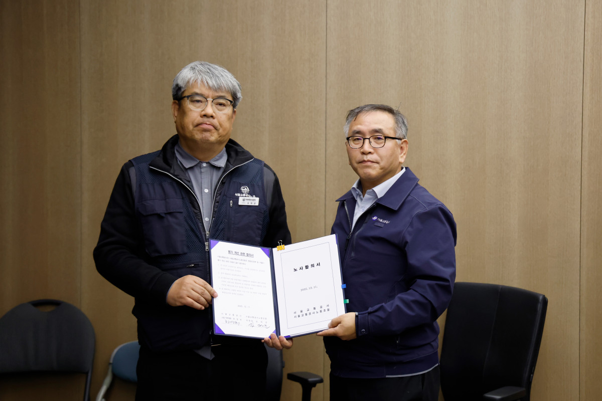 ▲태균 민주노총 공공운수노조 서울교통공사노조위원장(왼쪽)과 한영희 서울교통공사 기획본부장(사장 직무대행)이 12일 서울 성동구 서울교통공사 본사에서 임금·단체협약 합의서를 체결한 뒤 기념 촬영하고 있다. (연합뉴스)