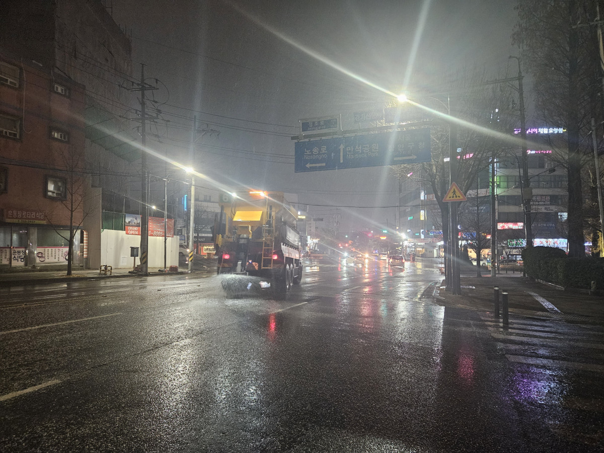 ▲수원시가 블랙아이스 발생 가능성에 대비해 야간 시간대 제설 차량을 투입하고 제설제를 살포하며 도로 결빙을 선제 차단하고 있다. (수원특례시)