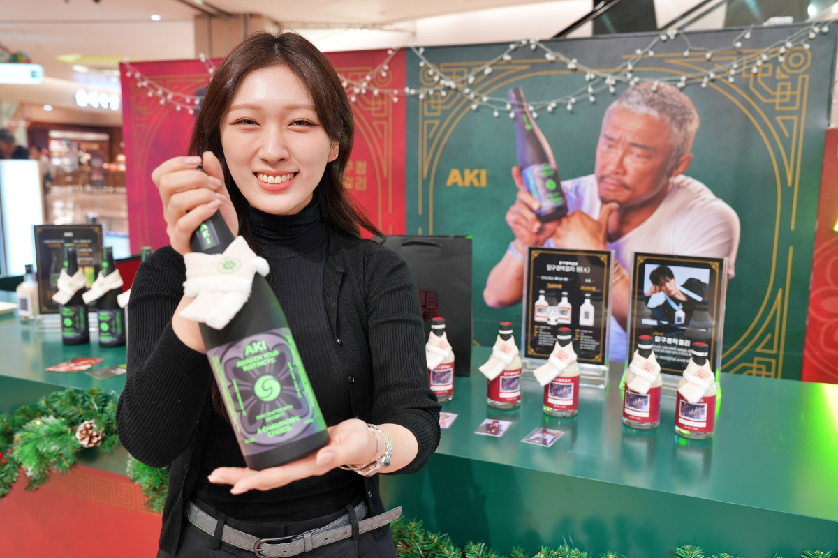 ▲14일 잠실 롯데월드몰에서 진행 중인 '압구정 막걸리 X 아키 사케' 컬래버 팝업스토어에서 모델이 상품을 선보이고 있다. (사진제공=롯데백화점)