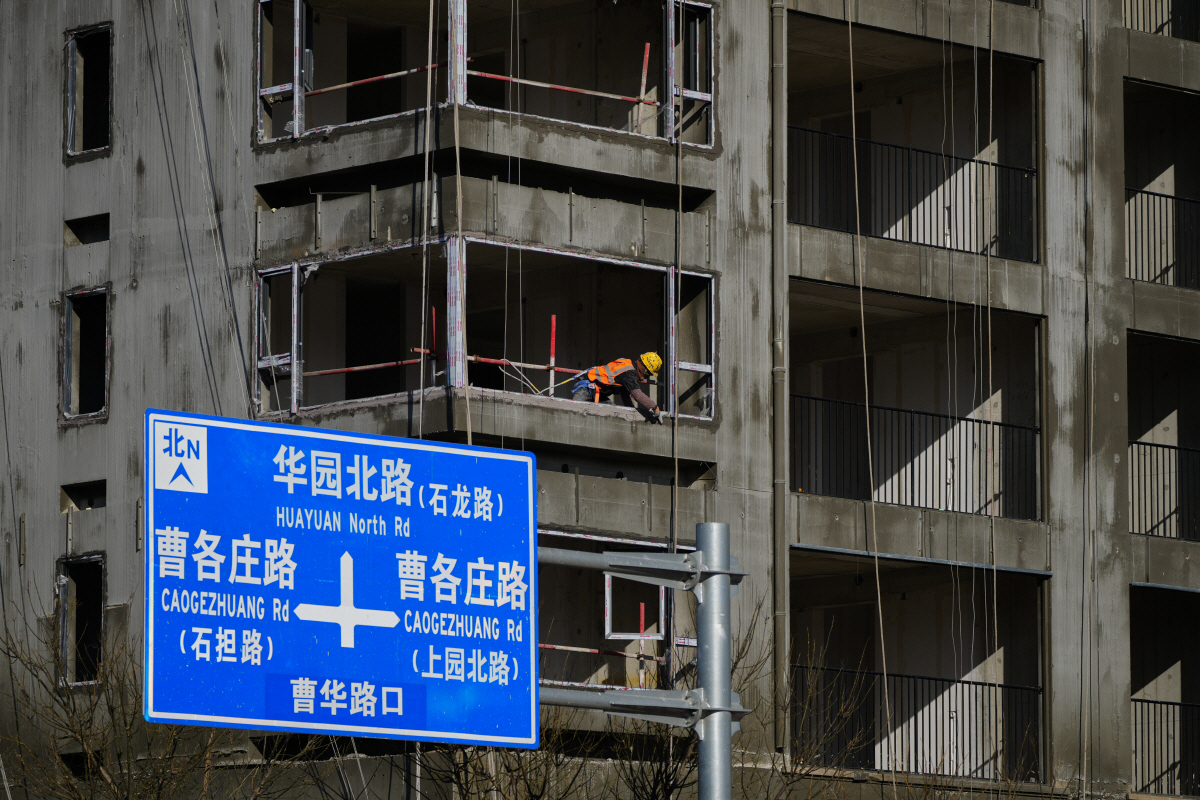▲중국 베이징에서 한 작업자가 건설 중인 주거용 건물에 창문 프레임 패널을 설치하고 있다.  (베이징/AP연합뉴스)