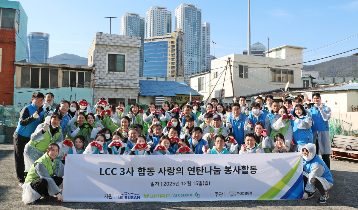 ▲15일 부산 범일동 일대에서 에어부산·진에어·에어서울 임직원들이 연탄 나눔 봉사활동에 참여해 기념촬영을 하고 있다. (사진=에어부산)