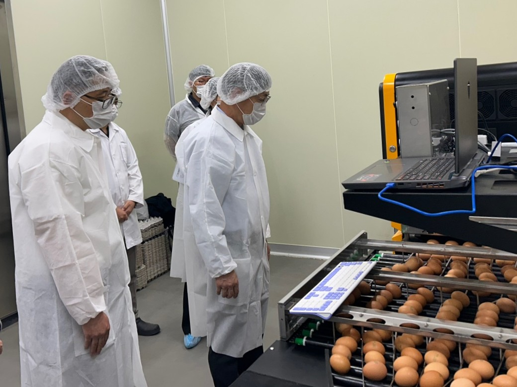 ▲박병홍 축산물품질평가원장(왼쪽에서 두 번째)이 인공지능 기반 계란 등급판정 기계 시연을 지켜보고 있다. (사진제공=축산물품질평가관리원)
