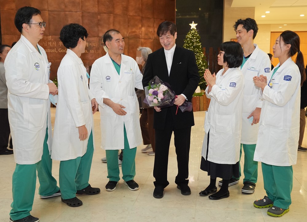 ▲‘왼손 피아니스트’ 이훈 씨(가운데)가 16일 오후 12시 30분 병원 로비에서 음악회를 개최하고 의료진으로부터 축하를 받고 있다. (가톨릭대학교 서울성모병원)