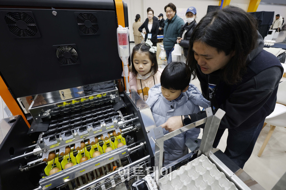 ▲21일 서울 서초구 aT센터에서 열린 '에그테크코리아 2025(EggTech Korea 2025)'에서 축산물품질평가원 부스에서 관계자가 어린이 관람객들에게 AI 기반 계란등급판정 기계에 대해 설명하고 있다. 고이란 기자 photoeran@