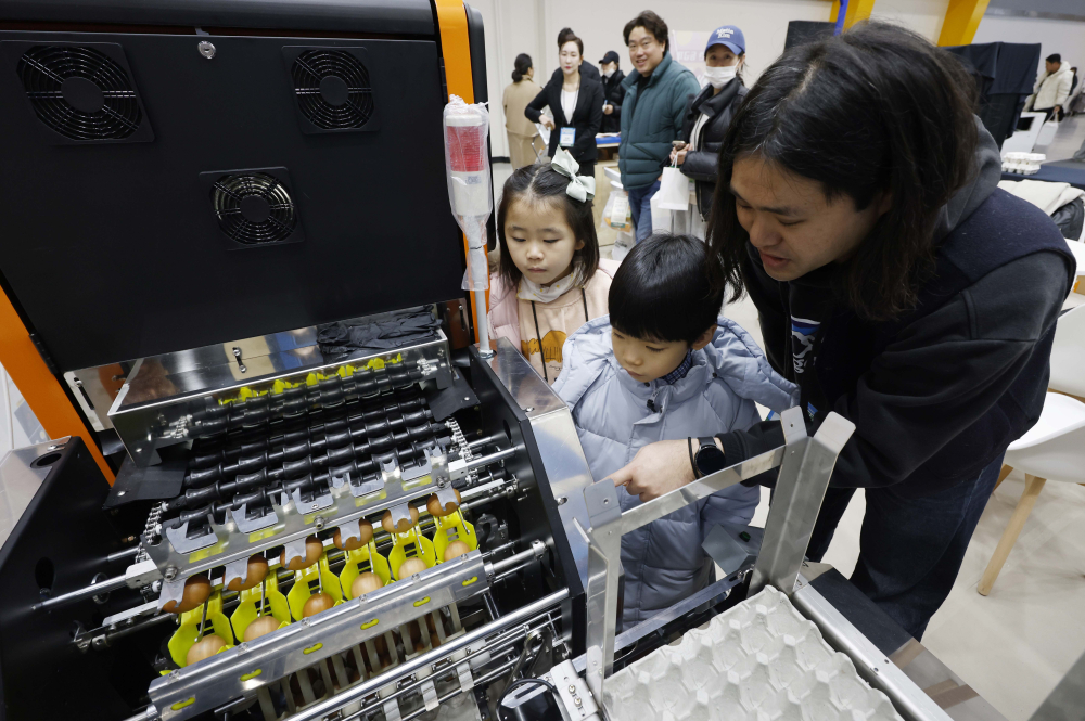 ▲21일 서울 서초구 aT센터에서 열린 '에그테크코리아 2025(EggTech Korea 2025)'에서 축산물품질평가원 부스에서 관계자가 어린이 관람객들에게 AI 기반 계란등급판정 기계에 대해 설명하고 있다. 고이란 기자 photoeran@ (이투데이DB)