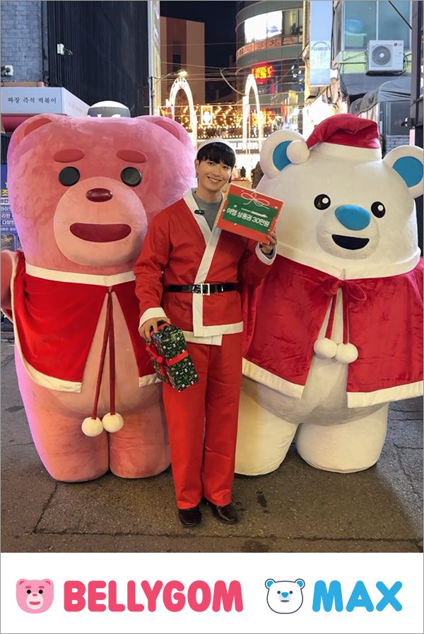 ▲호텔스컴바인의 자사 캐릭터 '맥스'(오른쪽)와 롯데홈쇼핑의 인기 캐릭터 '벨리곰'(왼쪽)이 산타 의상을 입고 시민들에게 깜짝 선물을 전하고 있는 모습 (사진제공=호텔스컴바인)