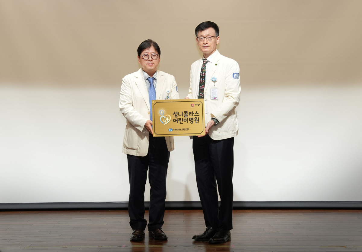 ▲이지열 서울성모병원장이 정낙균 성 니콜라스 어린이병원 초대 원장(우측)에게 현판을 수여하고 기념사진을 촬영하고 있다. (서울성모병원)