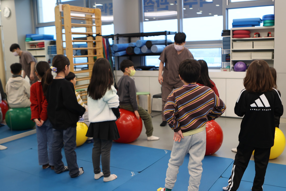 ▲연세하나병원 도수재활센터에서 진행된 ‘어린이 메디컬 캠프’ 프로그램에서 치료사의 지도로 아이들이 바른 자세와 신체 균형 교육을 받고 있다. (연세하나병원)