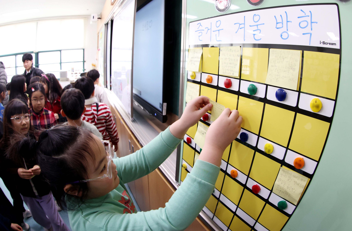 ▲24일 서울 동대문구 안평초에서 열린 겨울방학식에서 2학년 어린이들이 칠판에 방학계획을 적은 종이를 붙이고 있다. 신태현 기자 holjjak@