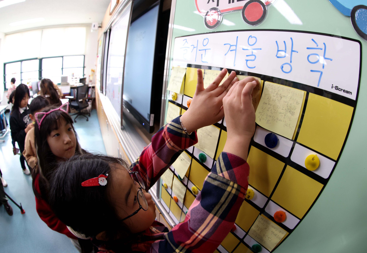 ▲24일 서울 동대문구 안평초에서 열린 겨울방학식에서 2학년 어린이들이 칠판에 방학계획을 적은 종이를 붙이고 있다. 신태현 기자 holjjak@