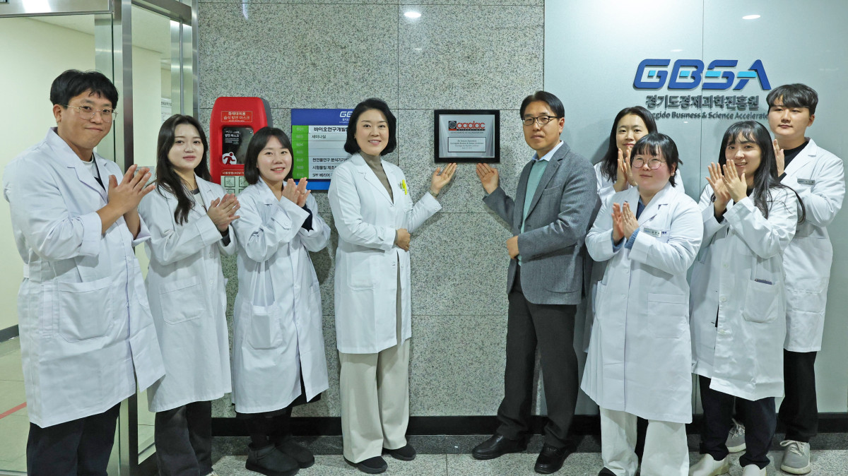 ▲경기도경제과학진흥원 바이오산업본부 관계자들과 실험동물실 운영 담당자들이 AAALAC International 완전 인증 획득을 기념해 현판 앞에서 기념 촬영을 하고 있다. 경과원 실험동물실은 국제 기준에 부합하는 윤리적 관리 체계를 인정받았다. (경기도경제과학진흥원)