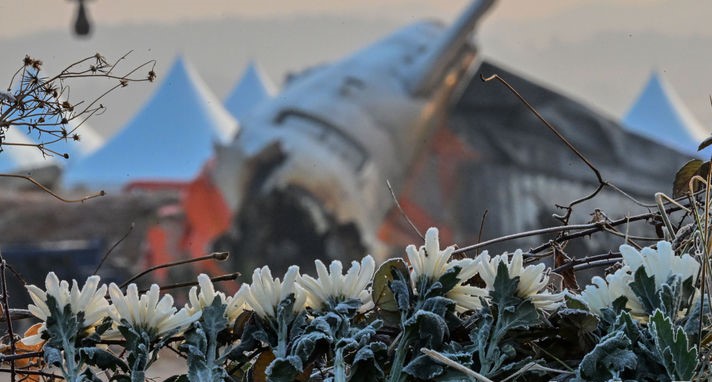 ▲ 제주항공 여객기 참사 1주기을 맞아 전남 무안군 무안국제공항 활주로 사고 현장에 파손된 여객기 동체가 놓여있다. 사고 현장 주변으로는 조문객들이 두고 간 국화가 놓여 서리를 맞고 있다.  (사진제공=뉴시스)