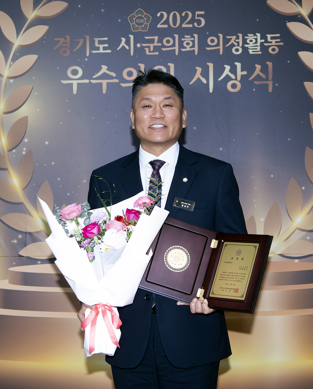 ▲황성석 김포시의회 의원이 지역경제활성화 분야 우수의원으로 선정돼 표창패와 꽃다발을 들고 기념촬영을 하고 있다. (김포시의회 )