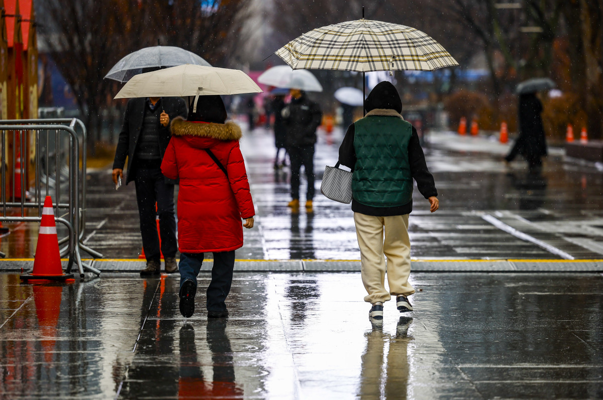 ▲우박과 비가 내린 23일 서울 종로구 광화문광장에서 우산을 쓴 시민들이 이동하고 있다. (뉴시스)