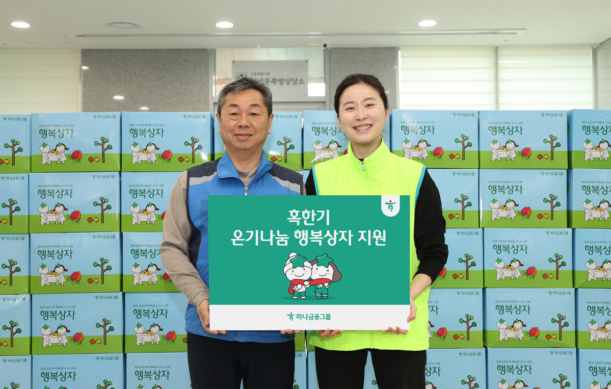 ▲하나금융그룹 직원이 29일 서울시 중구 남대문쪽방상담소를 방문해 온열담요·발열내의 등 혹한기 대비 용품이 담긴 행복상자를 전달하고 기념사진을 촬영하고 있다. (사진제공=하나은행)