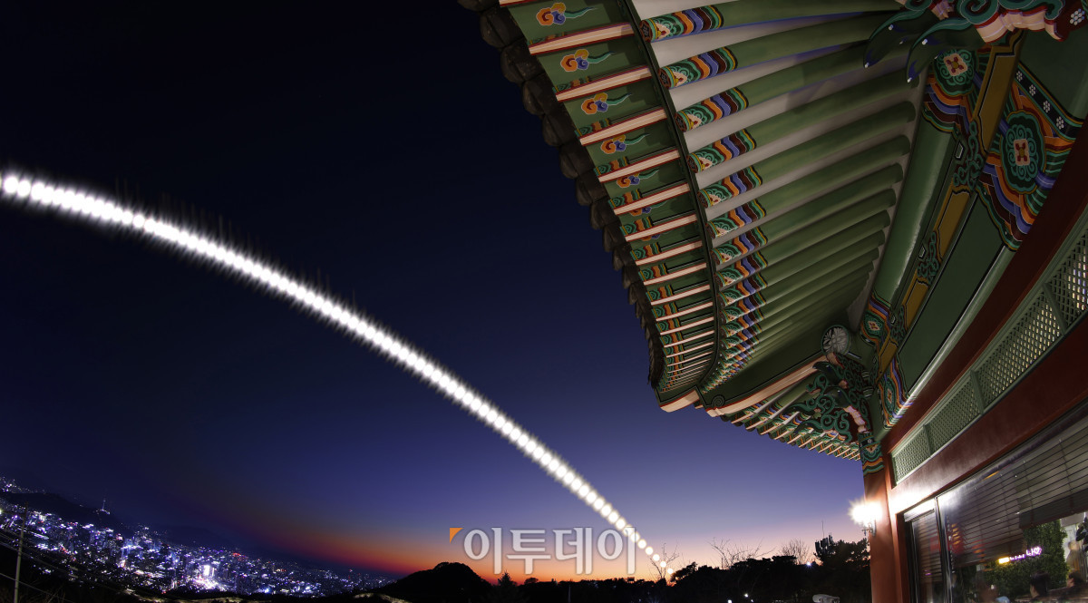 ▲북악팔각정 처마 아래 단청과 기와가 저무는 빛과 함께 한 해의 시간을 고요히 품는다. 올해 K-컬처는 플랫폼을 타고 세계로 뻗어갔다. 영화 '케이팝 데몬 헌터스'는 누적 3억 뷰를 돌파하며 넷플릭스 역대 최고 기록을 새로 썼다. 작품 속 남산타워와 북촌한옥마을, 낙산공원 등 이른바 ‘케데헌 8경’으로 불린 서울의 명소들은 성지순례로 불리며 새로운 관광 풍경을 만들었다. 이러한 흐름은 전통과 역사를 품은 문화 공간으로 확장됐다. 국립중앙박물관은 개관 이래 처음으로 연간 관람객 600만 명 시대를 열었다. 한 해의 빛이 저무는 순간, 한국 문화는 더 넓은 세계를 향해 다음 장을 열고 있다(캐논 EOS R3 조리개 22, 셔터스피드 1/8000, 감도 100, 연속 촬영된 91장의 사진을 레이어 합성). 조현호 기자 hyunho@