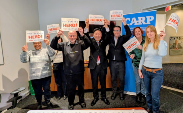 ▲대한은퇴자협회(KARP)와 캐나다은퇴자협회(CARP) 관계자들이 캐나다 토론토 본부에서 ‘당신은 이 시대의 영원한 주인공 HERO!’라는 문구가 적힌 깃발을 함께 펼쳐 보이며 양국 시니어의 권익 증진을 다짐하고 있다.(대한은퇴자협회 제공)