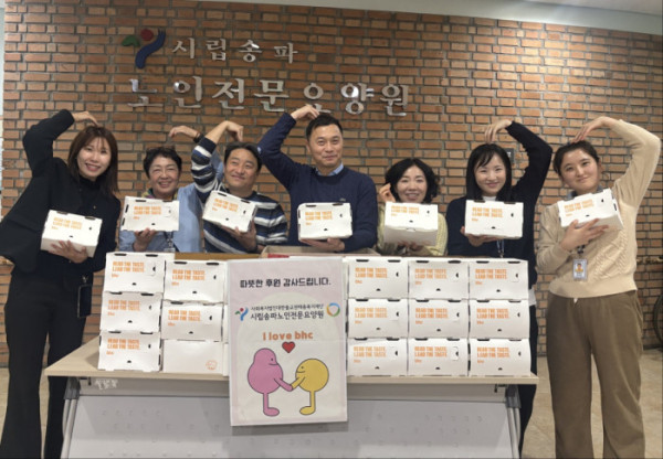 ▲시립송파노인전문요양원 관계자가 기념 사진을 촬영하고 있다.(사진제공=bhc)