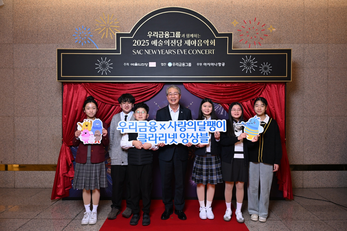 ▲(사진 가운데) 임종룡 우리금융그룹 회장과 사랑의 달팽이 클라리넷 앙상블 단원들이 지난달 31일 예술의 전당에서 열린 제야음악회에 참석해 기념사진을 촬영하고 있다. (사진제공=우리금융)