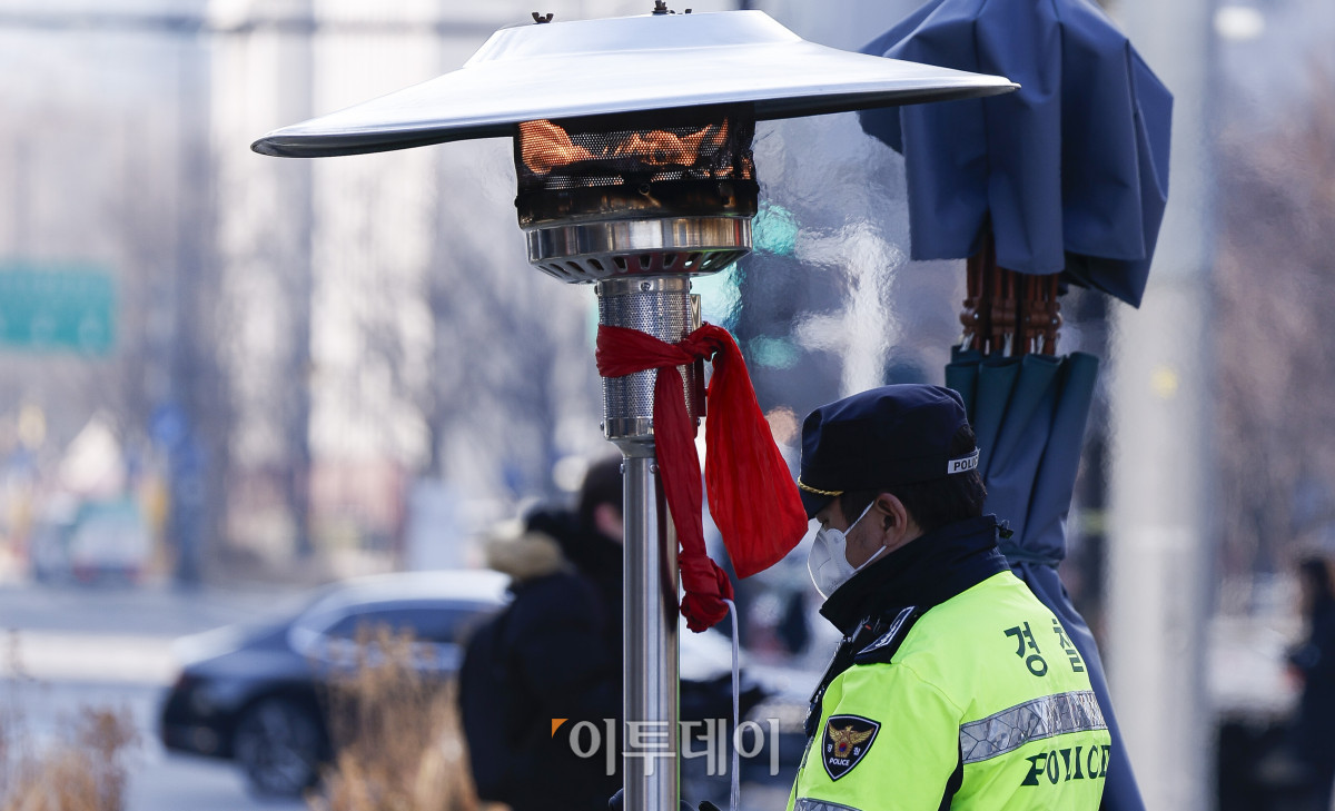 ▲절기상 소한(小寒)인 5일 경찰관이 서울 종로구 광화문광장에 설치된 난로에서 몸을 녹이고 있다. 기상청은 이날 전국의 아침 최저기온은 영하 9도에서 영상 3도로 예보했다. 조현호 기자 hyunho@