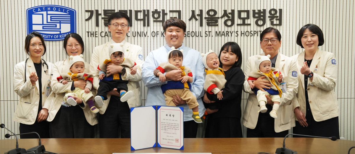 ▲서울성모병원 다섯쌍둥이 가족이 홍보대사 위촉 기념촬영을 하고 있다. 좌측부터 윤영아 신생아중환자실장, 홍수빈 산부인과 교수, 정낙균 성 니콜라스 어린이병원장, 김준영·사공혜란 부부, 이지열 서울성모병원장, 박혜정 재활의학과 교수. (서울성모병원)