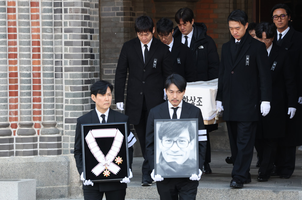 ▲9일 서울 중구 명동성당에서 열린 배우 안성기의 장례 미사가 끝난 뒤 영결식을 위해 고인의 영정과 금관문화훈장을 든 배우 정우성, 이정재가 영결식장으로 향하고 있다.  (연합뉴스)