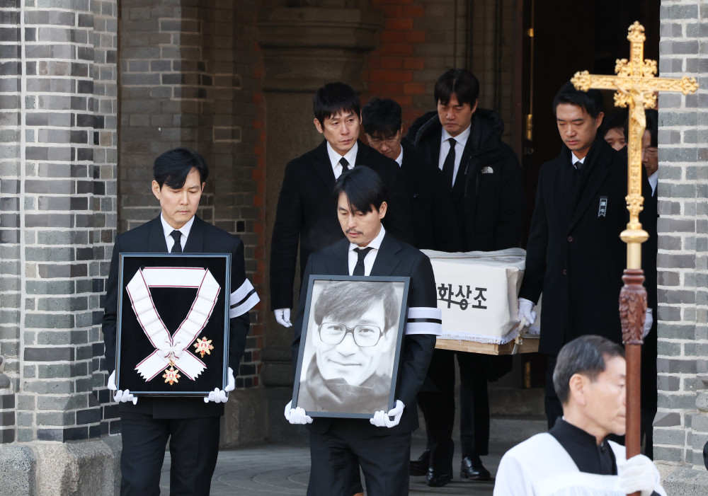 ▲9일 서울 중구 명동성당에서 열린 배우 안성기의 장례 미사가 끝난 뒤 영결식을 위해 고인의 영정과 금관문화훈장을 든 배우 정우성, 이정재가 영결식장으로 향하고 있다.  (연합뉴스)