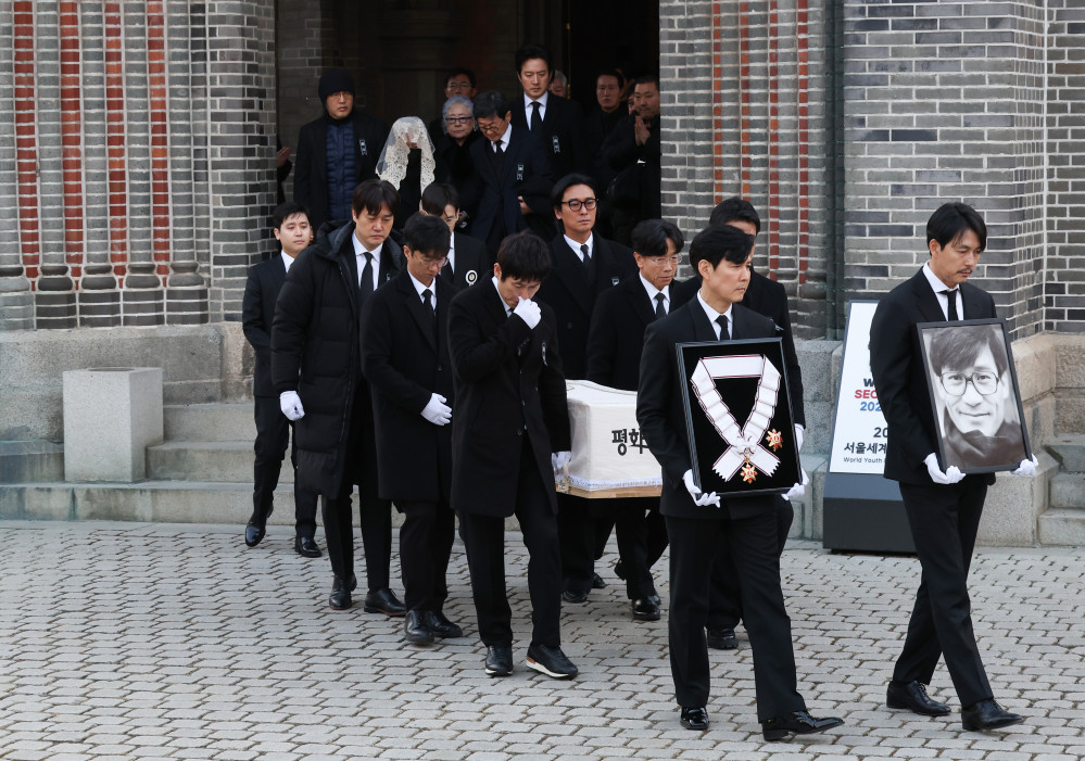 ▲9일 서울 중구 명동성당에서 열린 배우 안성기의 장례 미사가 끝난 뒤 영결식을 위해 고인의 영정과 금관문화훈장을 든 배우 정우성, 이정재가 영결식장으로 향하고 있다.  (연합뉴스)