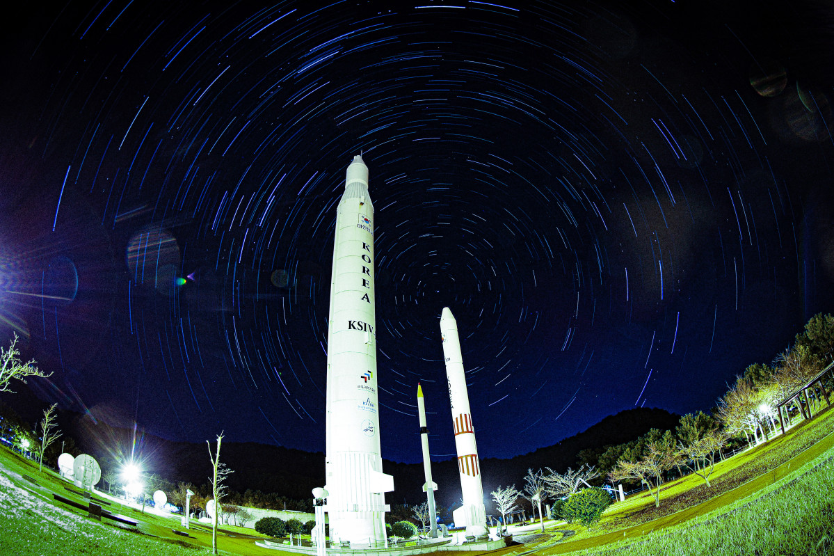 ▲나로우주센터 우주과학관 로켓광장에 우리나라에서 개발된 1단형 고체추진 로켓 KSR-Ⅰ, 2단형 고체추진로켓 KSR-Ⅱ, 액체추진 과학로켓 KSR-Ⅲ, 우주발사체 KSLV-Ⅰ(나로호)의 실물크기 로켓 모형 뒤로 별의 일주운동 궤적이 보이는 모습. (별의 일주운동 궤적은 30초로 2시간 촬영 후 각각의 사진 레이어 합성) (뉴시스)