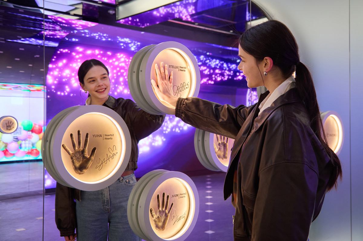 ▲한 외국인 관광객이 롯데면세점 '스타에비뉴' 스타에비뉴 입구 양쪽에 있는 하이파이브 존에서 롯데면세점 신규 모델 걸그룹 '하츠투하츠'의 핸드프린팅에 손을 마주대며 즐거워하고 있다. (사진제공=롯데면세점)