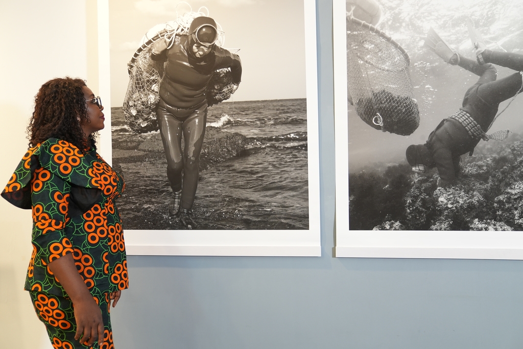 ▲제주 해녀 사진 둘러보는 나이지리아 관람객. (사진제공=주나이지리아한국문화원)