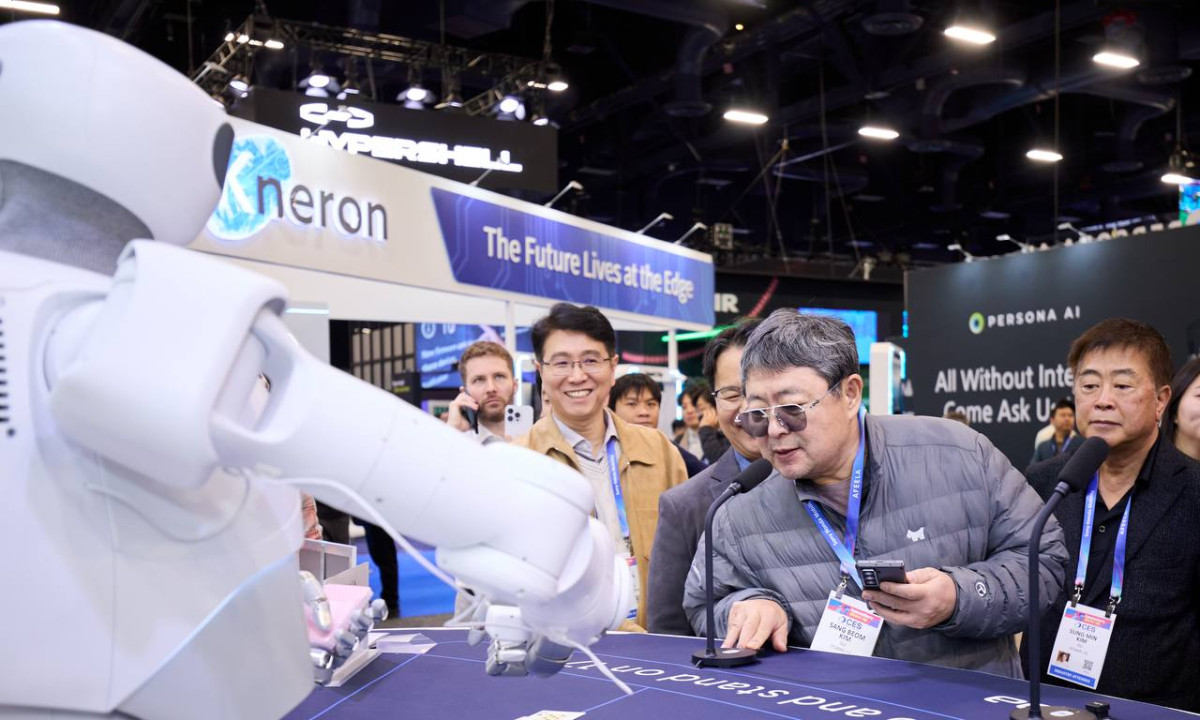 ▲이수그룹 김상범(앞줄 가운데) 회장이 CES 2026에서 피지컬 AI 기업 부스를 둘러보며 로봇과 대화를 나누고 있다. (사진제공=이수그룹)