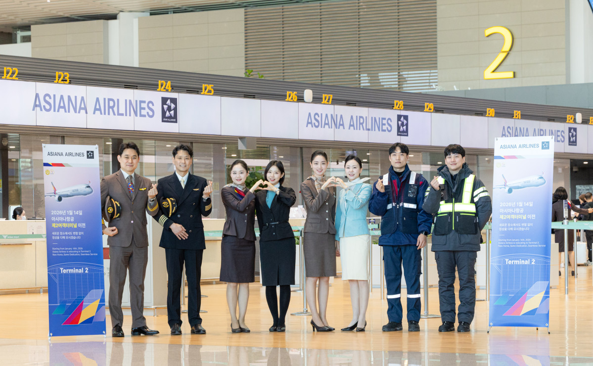 ▲아시아나항공이 14일 인천공항 제 2 여객터미널에서 운항을 시작했다. 아시아나항공과 대한항공 양사 직원들이 터미널 이전 기념 촬영을 하고있다. (사진=아시아나항공)